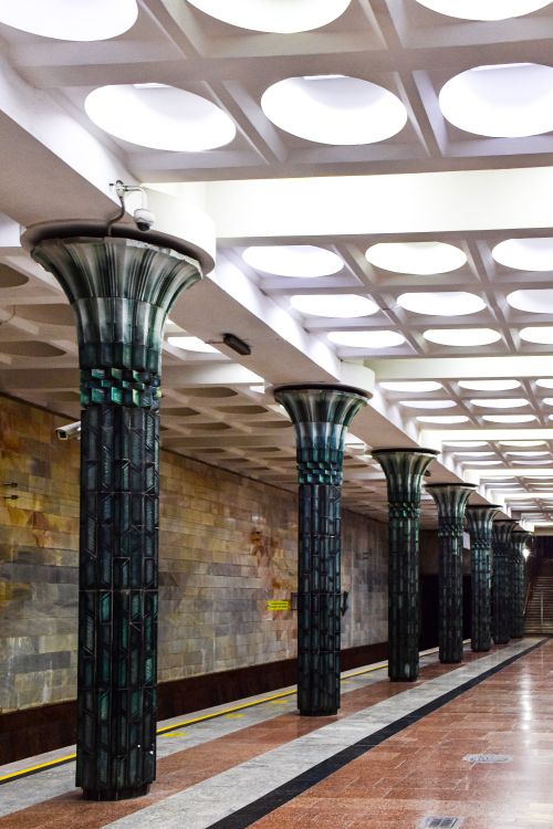 Ornate marble columns inside a Tashkent metro station showing Soviet-era architecture